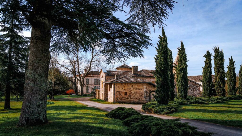 Château et bâtiments en pierre vus depuis le parc