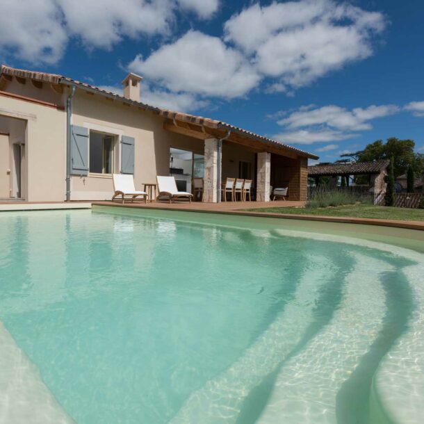 Piscine extérieure avec terrasse et transats dans une villa