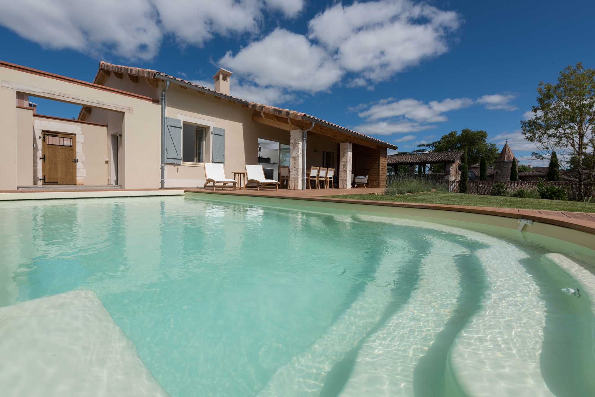 Piscine extérieure avec terrasse et transats dans une villa