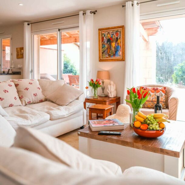 Salon lumineux d’une villa avec canapé et grandes fenêtres