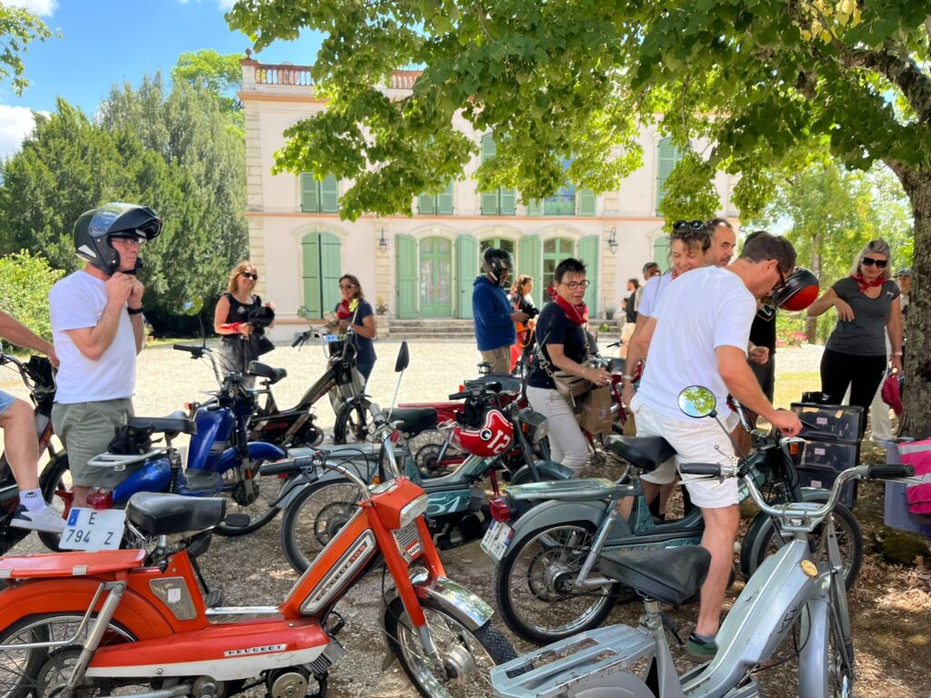 Groupe près de cyclomoteurs anciens devant le château