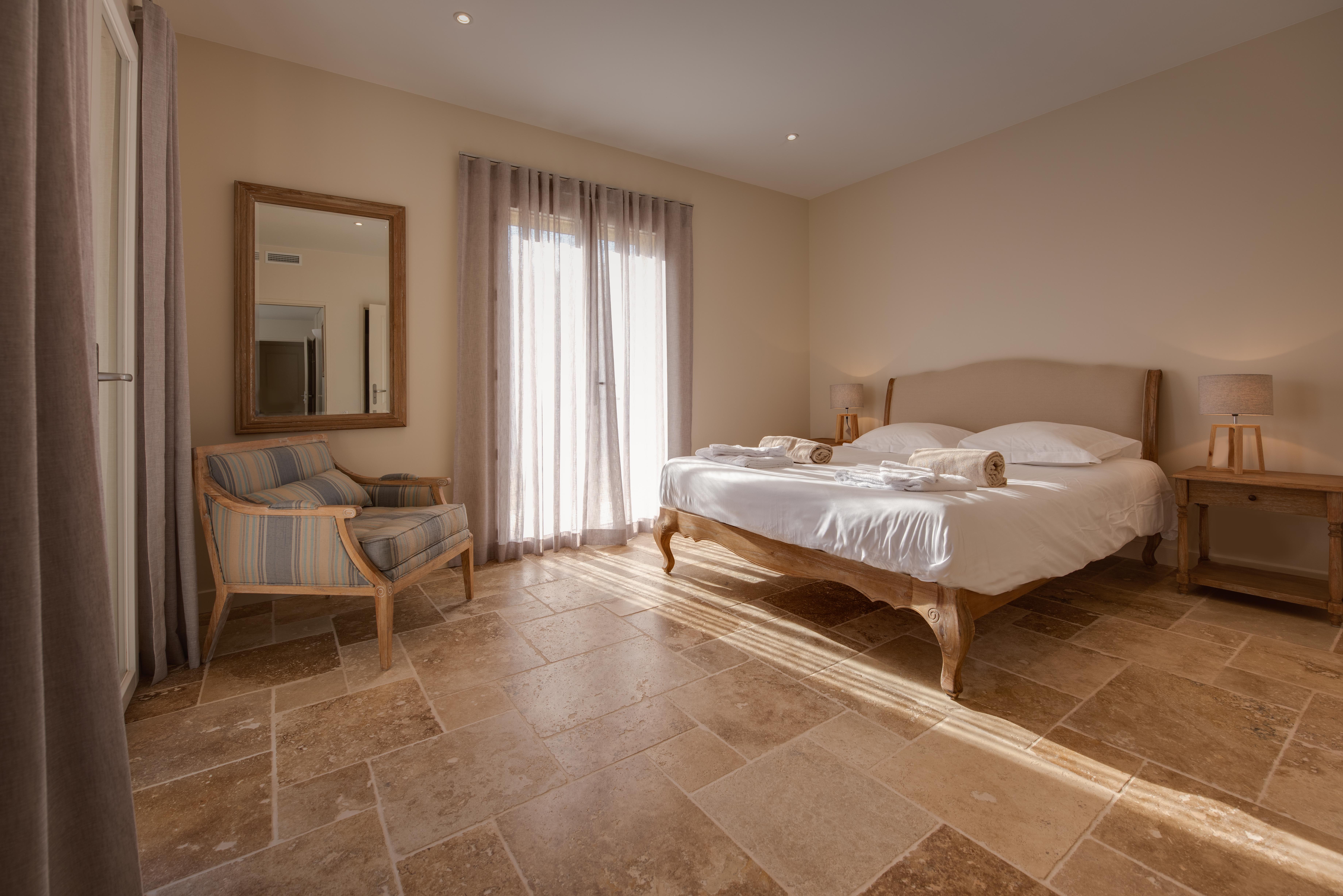 Chambre lumineuse avec lit double et fauteuil