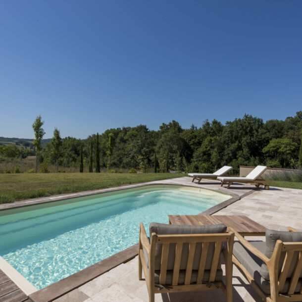 Piscine extérieure avec terrasse et transats dans une villa